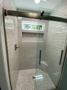 This image features a walk-in shower with white tile.