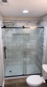 This image features a walk-in shower with grey tile.