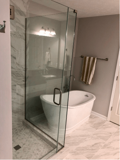 Modern bathroom with bathtub and glass enclosure in a clean, bright design