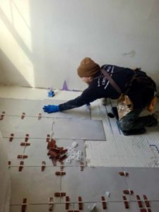 Artistic Tile & Design tile installer working on flooring in Indiana