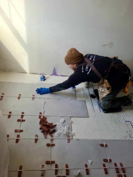 Artistic Tile & Design tile installer working on flooring in Indiana