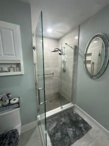 A modern bathroom with large format walls and mosaic tile floor.