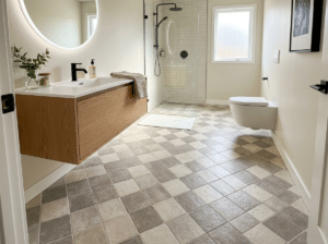 A bathroom floor with diagonal tile pattern.