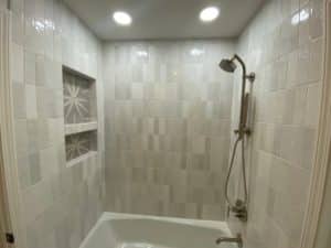 A tub surround with stacked tile pattern.